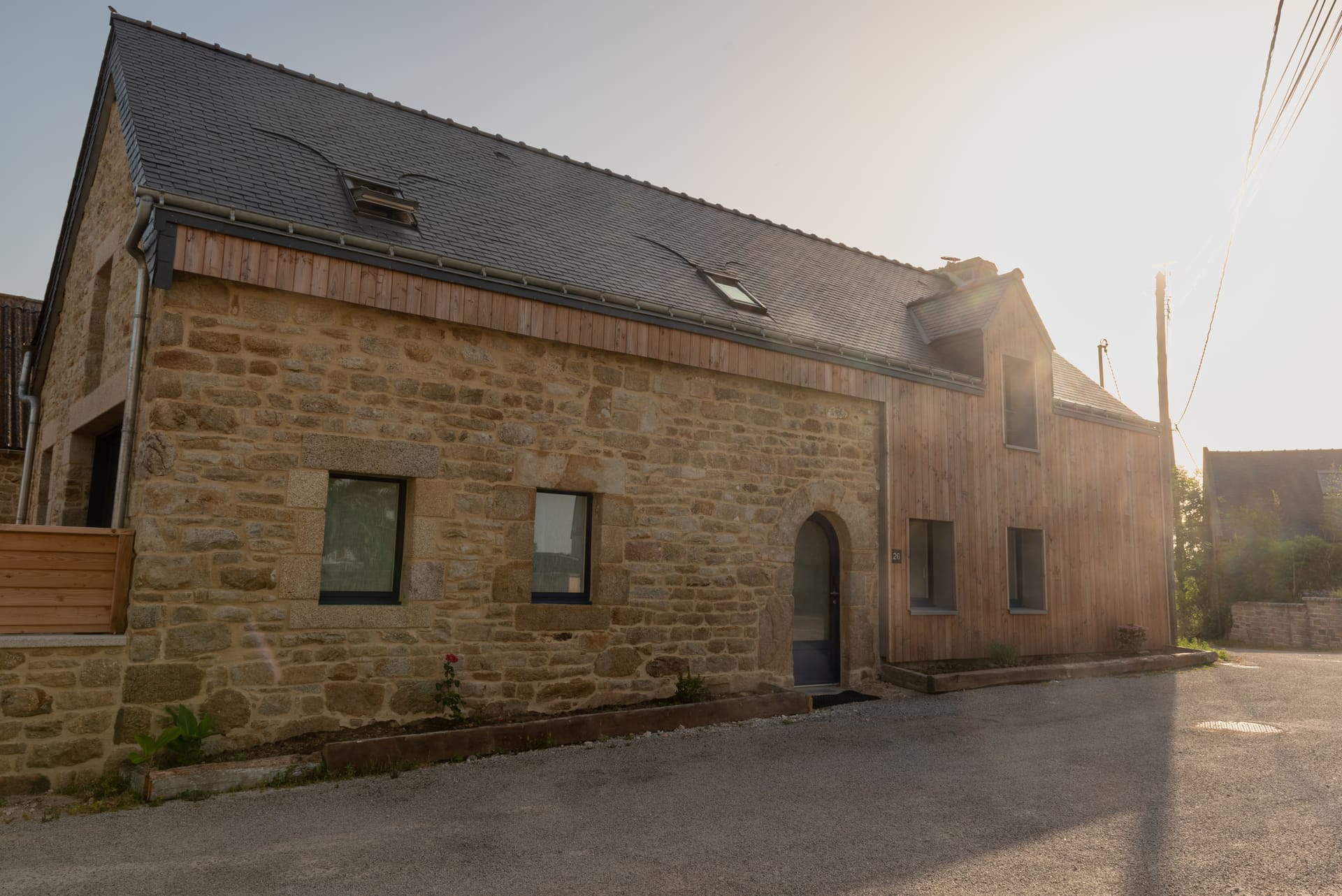 La Grange Côté Mer, façade en pierre et bois au coucher du soleil