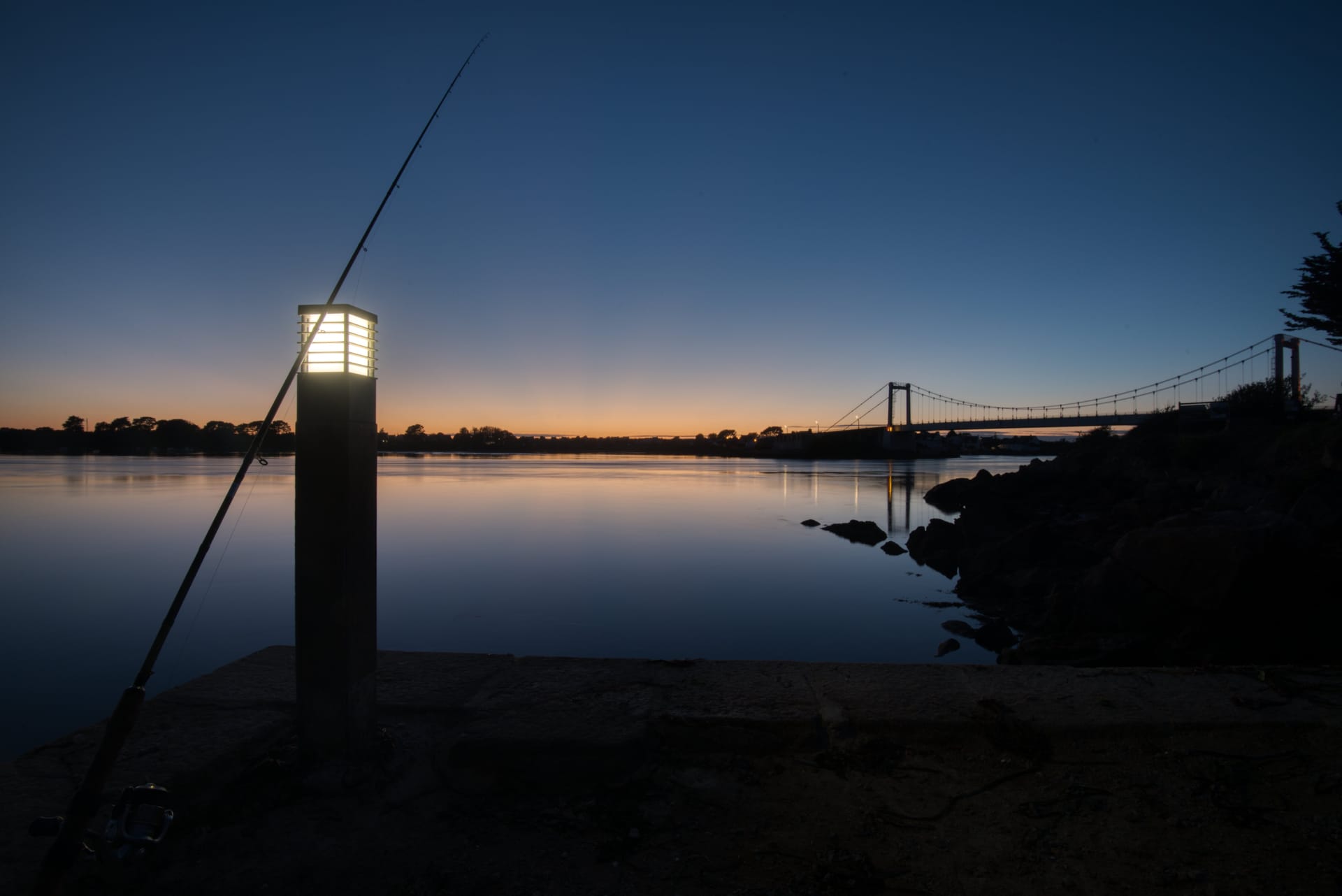 Canne à pêche au crépuscule face au Pont Lorois