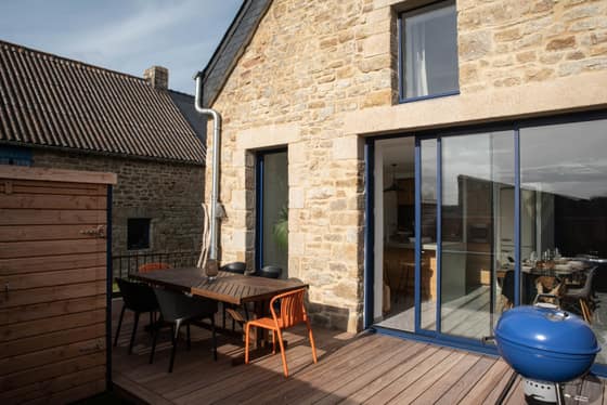Terrasse en teck et dîner dressé à la tombée de la nuit