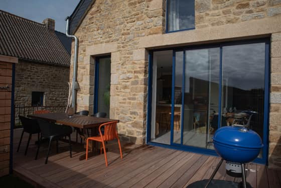 Table et chaises sur la terrasse en bois, barbecue